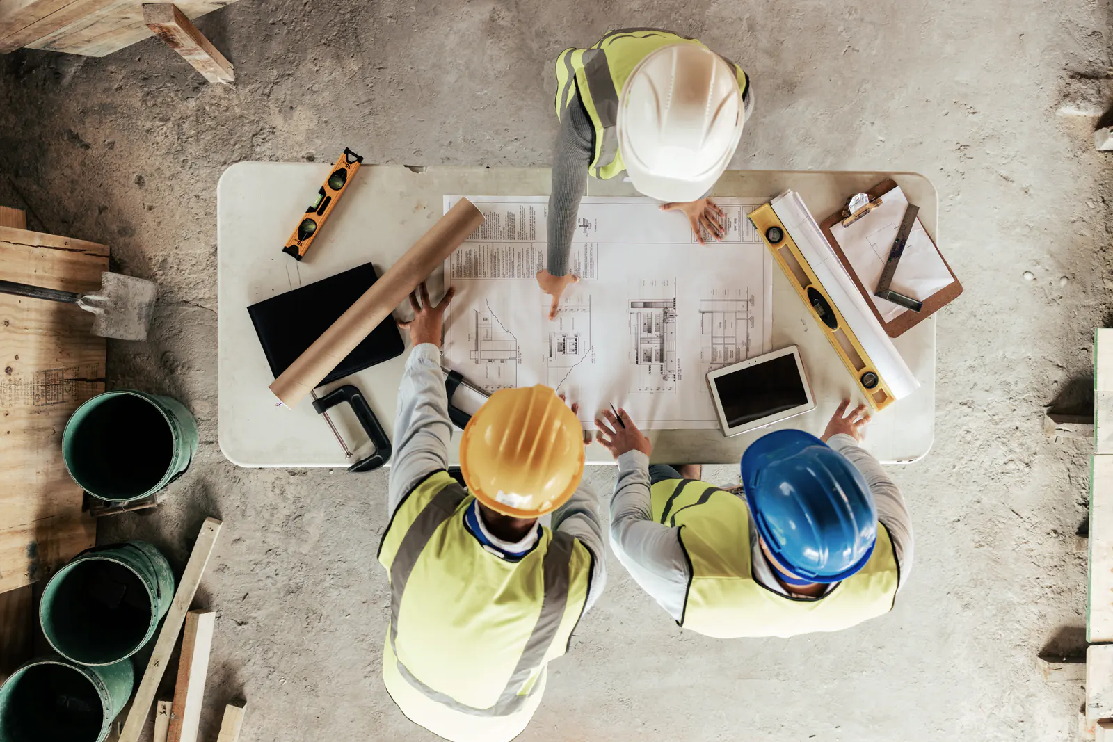 Construction team coordinating work from project drawings