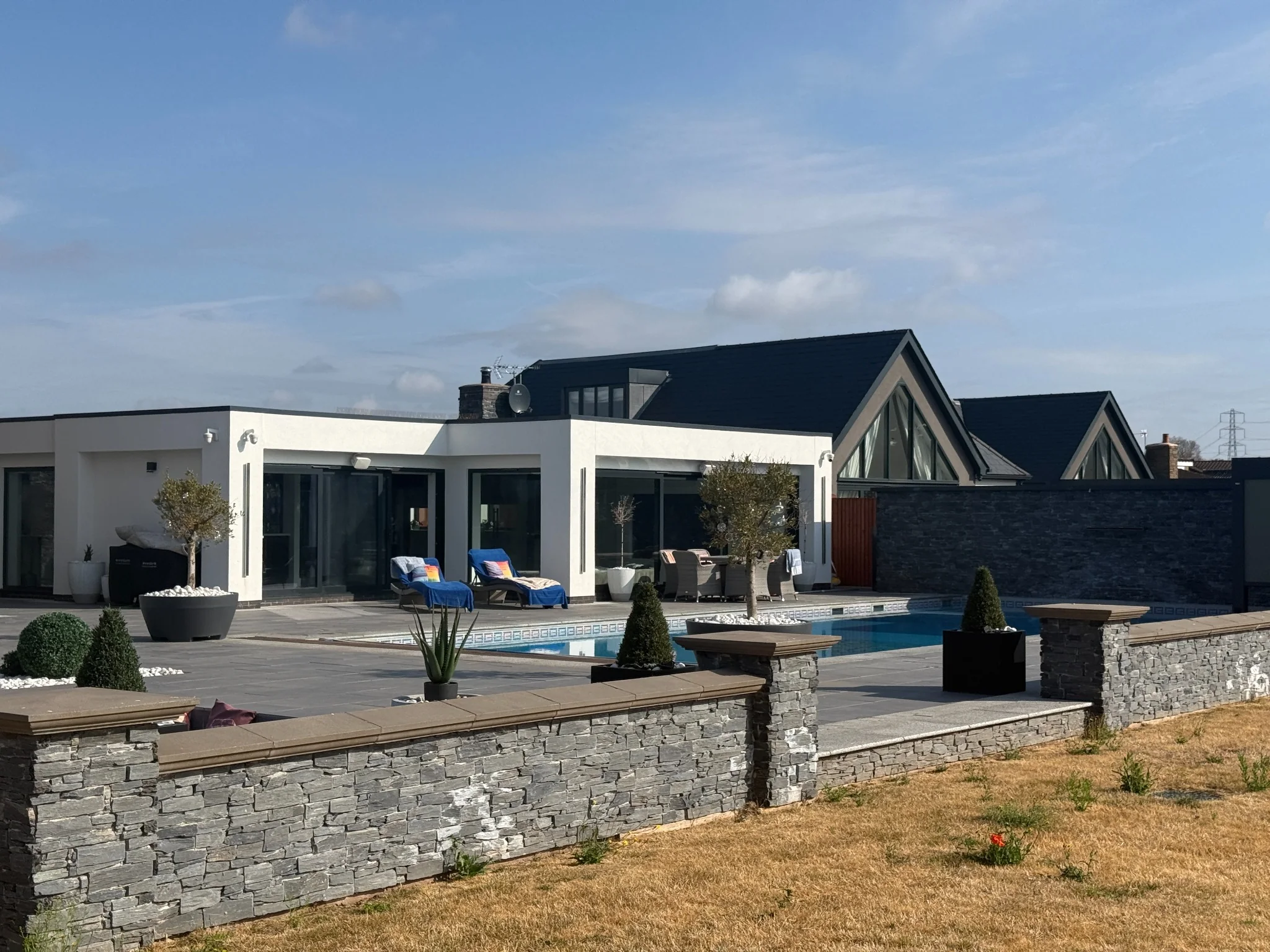 Garden elevation of the completed Project 1257 residence with pool terrace, natural stone and timber cladding