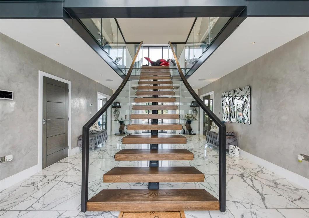 Central open-tread staircase within the double-height entrance hall