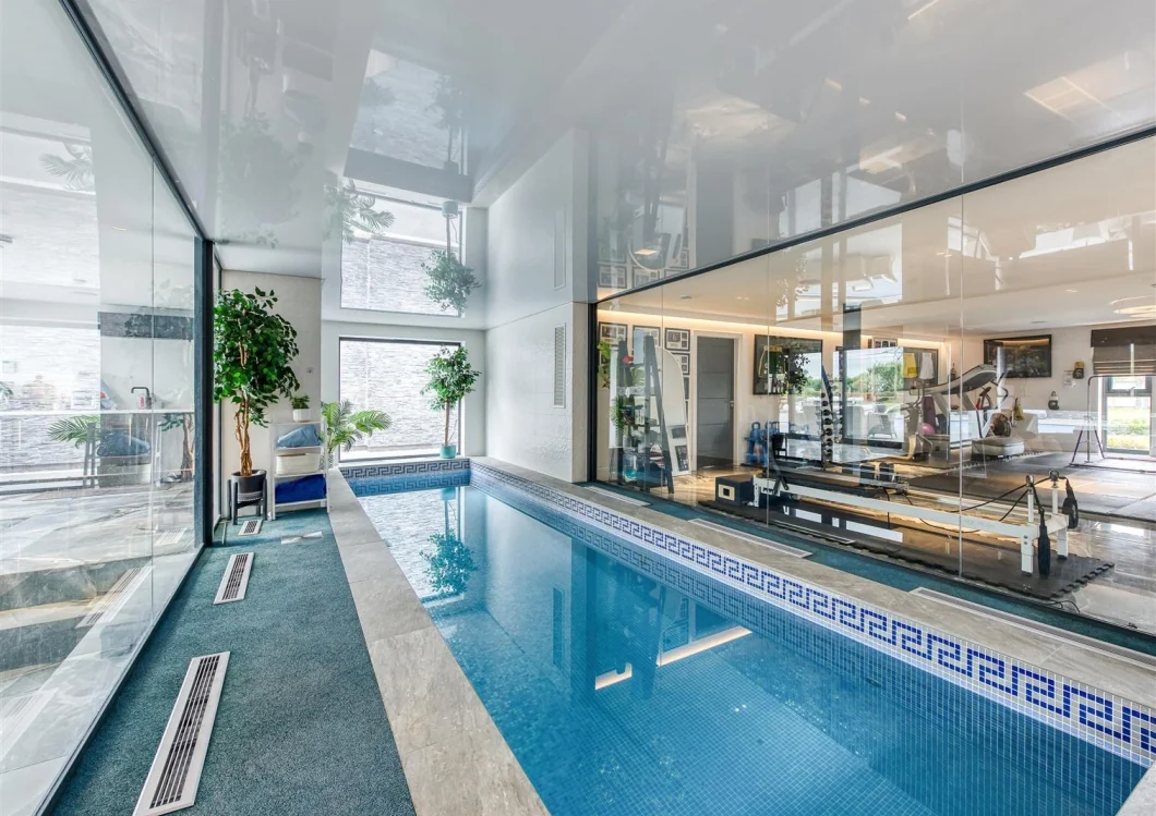 Indoor swimming pool connected visually to the adjoining gym