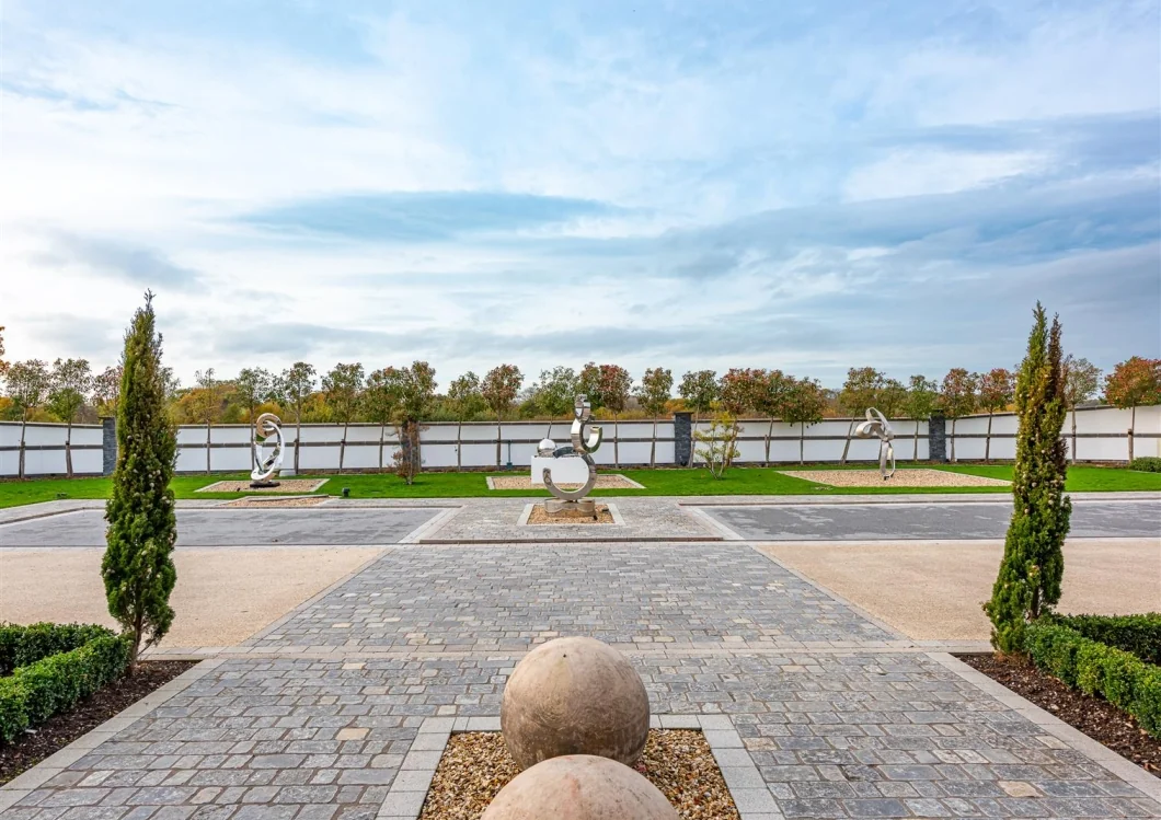 Landscaped arrival court with sculpture and structured planting